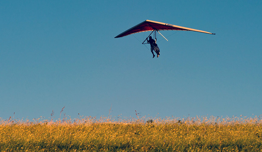 A participant of the Ascending Flow Festival on Klementyev Hill near Koktebel, Crimea, flying a paraglider